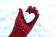 © Suchana - Heartshaped snowball carefully held in a red woolen mitten on snowy ground