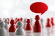 © Daria - Red and white wooden figurines with one red figure speaking through a bold red speech bubble symbolizing communication and leadership concepts in a crowd
