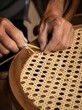 © Christopher - Artisan hands weaving natural rattan webbed chair - Handcrafted furniture restoration concept - Vertical portrait
