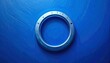 © Rini - Close up of a metallic circular lens ring on blue background.