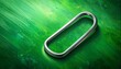 © Rektor - Close up of a metallic oval ring on green textured background.