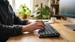 ©   BrightNest Studio - A professional working at a desk, typing on a keyboard in a modern workspace environment.