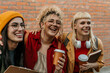 © La Famiglia - Diverse students laughing together enjoying coffee outside university