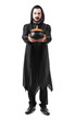 © Pixel-Shot - Young man dressed as vampire for Halloween with cauldron of candy corns on white background