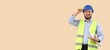 © Pixel-Shot - Smiling young male engineer in a blue hard hat and safety vest holding rolled blueprints, construction and architecture professional