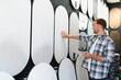© Serhii - Man choosing decorative plaster samples for home improvement