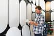 © Serhii - Man choosing decorative plaster samples for interior design