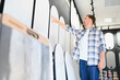 © Serhii - Man choosing decorative wall panels in design studio
