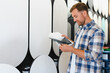 © Serhii - Man choosing decorative plaster samples in studio
