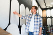 © Serhii - Man customer choosing decorative plaster textures in design studio