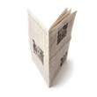 © Toni Kristiadi - Newspaper standing upright on a white background with black and white print and photographs