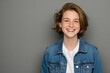 © Oleksandr - Teenage girl with freckles smiles broadly. She wears denim jacket over white shirt. Studio portrait on gray background. Youthful, happy, casual look.