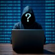 © Zack Ahmad - Anonymous hooded hacker sitting at a laptop with a question mark face surrounded by digital binary code background
