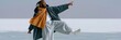 © Iryna - Joyful man in winter scarf and coat dancing on frozen lake for lifestyle banner background and poster design