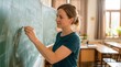 © Oleh - Educator Writing Thoughtful Lessons on a Traditional Classroom Chalkboard