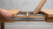 © Creative Store - Close up of a hand opening a wooden extendable dining table with metal sliding rails and ad social media download thambnail poster web template event festival 2026 2027 2028