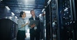 © Gorodenkoff - Caucasian Male Engineer Holding Laptop Computer Points up at Server Rack Hardware While Asian Female Supervisor Observes, Two Data Center Specialists Conducting Cloud Storage Capacity Audit