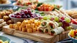 © tynza - Stylish children's party grazing table with bite sized healthy snacks, cheese cubes, grapes, mini wraps and colorful vegetables in a clean modern presentation