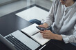 © tippapatt - Woman sitting on the floor, remote working at home, using smartphone with digital tablet and laptop on table, online job, e-business concept