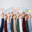 © Rizwan Akbar - Diverse raised hands with open palms reaching for blank colorful speech bubbles on light grey surface.