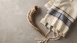 © Aklima - Shofar horn and tallit prayer shawl on a textured grey background, traditional jewish religious symbols for rosh hashanah and yom kippur holidays