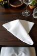 © kornc - White napkin folded neatly on dark wooden table
