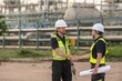 © BESTIMAGE - Engineers team discussing petroleum engineering in oil refinery project collaboration at fuel industrial plant Two engineers handshaking near oil refinery during site inspection and agreement