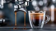 © Aris Suwanmalee - Freshly brewed espresso dripping from machine into a transparent glass cup.