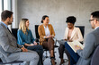 © NDABCREATIVITY - Multicultural professional businesspeople working together on research plan in boardroom.