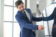 © unikyluckk - Portrait of positive business man looking at camera in modern office. Business consultant meeting is discussing financial situation, analyzing budget and planning business investments. Business