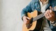 © Rasheda - A senior man playing an acoustic guitar to celebrate the international day of older persons with music and joy