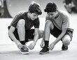 © PutriNurAlleya - Two Teenagers Tying Shoelaces Together in Black and White Photography at Skate Park
