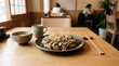 © sambath - Okonomiyaki on a wooden table with chopsticks and a cup of tea. The Japanese food concept of savory and flavorful.