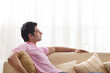 © IndiaPix - Young man day dreaming while relaxing on sofa
