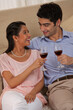 © IndiaPix - Relaxed young couple holding wineglass together at home