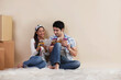 © IndiaPix - Young couple reading magazine together at their new home