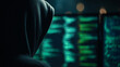 © abdulqayyom - Mysterious hooded hacker writing complex computer code on dark screens during a late night work session