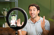 © VictorCanalesStudio - Man creating a vlog using a smartphone and ring light for social media streaming