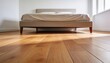 © Future Vision - Framing beige upholstered bed occupying center in minimal bedroom, sunlight patch from right window