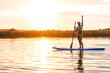 © milanmarkovic78 - Teen Girl Enjoys Summer Paddleboarding on a River at Sunset While Greeting the Camera
