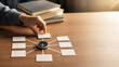 © Preeyanuch - College prep checklist concept with hand arranging blank cards around compass on wooden desk, books in background, planning and organization idea