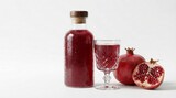 Red pomegranate juice drink in glass bottle and goblet with fresh fruit