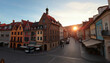 © Alla - Sunrise over historic European cobblestone street with old brick buildings and warm golden light