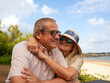 © ADDICTIVE STOCK - Senior couple embrace on beach during sunny vacation