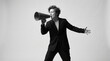 © ALI - Assertive Professional Woman in Suit Speaking Through Megaphone Against Gray Background
