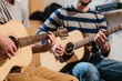 © oksa_studio - Musicians playing acoustic guitars and practicing music together in a home studio