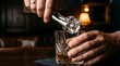 © Wandering - Man placing ice cube into whiskey glass with tongs at a dark bar