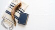 © ammaralaika - Jewish shofar placed on a tallit prayer shawl alongside a blue book over a white background.