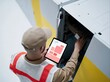 © Ryzhkov - Technician in a reflective vest and cap working with patch cords in a server rack, featuring a tactile, functional atmosphere for network support and field service
