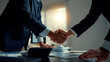© amnaj - Two business partners shaking hands after successful negotiation, symbolizing deal, collaboration, and mutual trust in an office